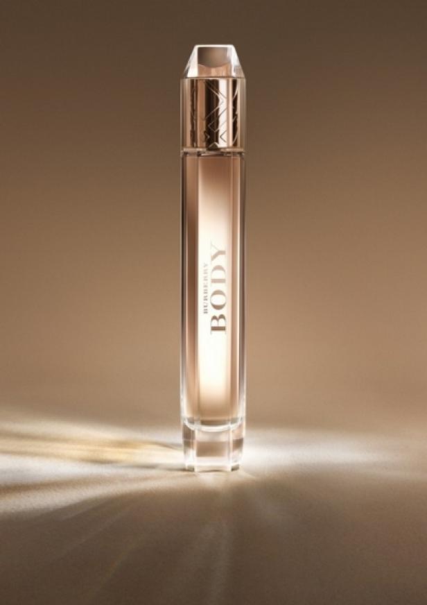 Eine Flasche „Burberry Body“ Parfüm steht auf einem hellbraunen Untergrund.