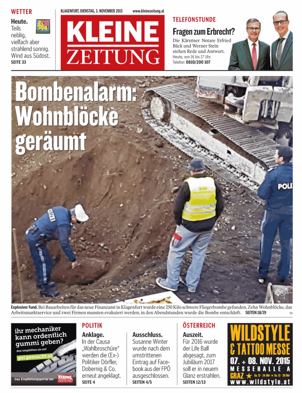 Polizisten untersuchen eine freigelegte Fliegerbombe auf einer Baustelle in Klagenfurt.