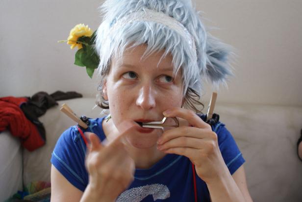 Eine Frau mit blauem Haar spielt auf einer Maultrommel.