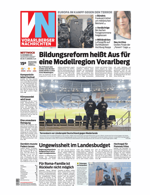Zwei Polizisten stehen vor einem leeren Fußballstadion, vermutlich im Einsatz.