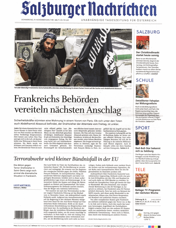 Ein Mann hält eine Flagge des Islamischen Staates und einen Koran hoch.