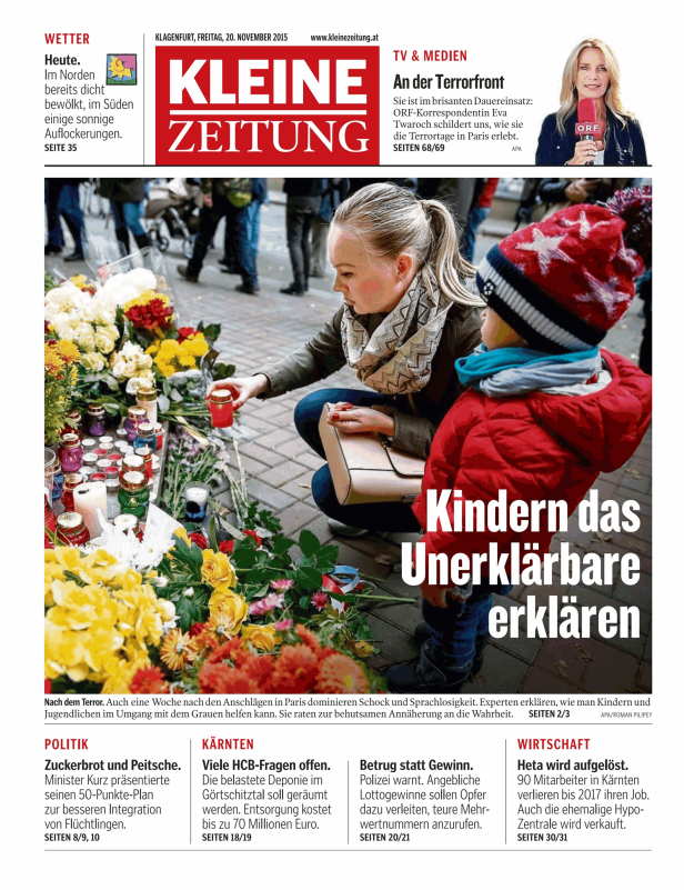 Eine Frau und ein Kind zünden Kerzen an einem improvisierten Mahnmal an.
