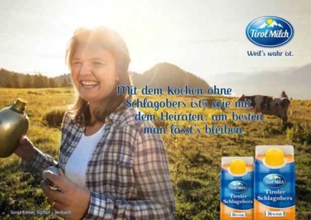 Eine lachende Frau hält eine Feldflasche in einer ländlichen Szene mit Tirol Milch Werbung.