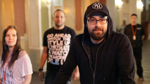 Ein Mann mit Bart und New York Yankees-Kappe lächelt in die Kamera.