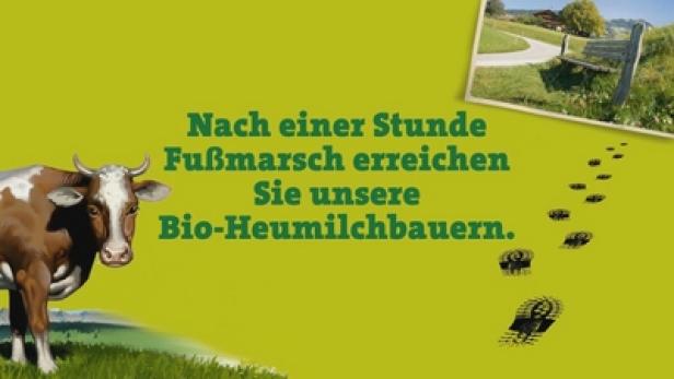 Eine Kuh und der Text: „Nach einer Stunde Fußmarsch erreichen Sie unsere Bio-Heumilchbauern.“