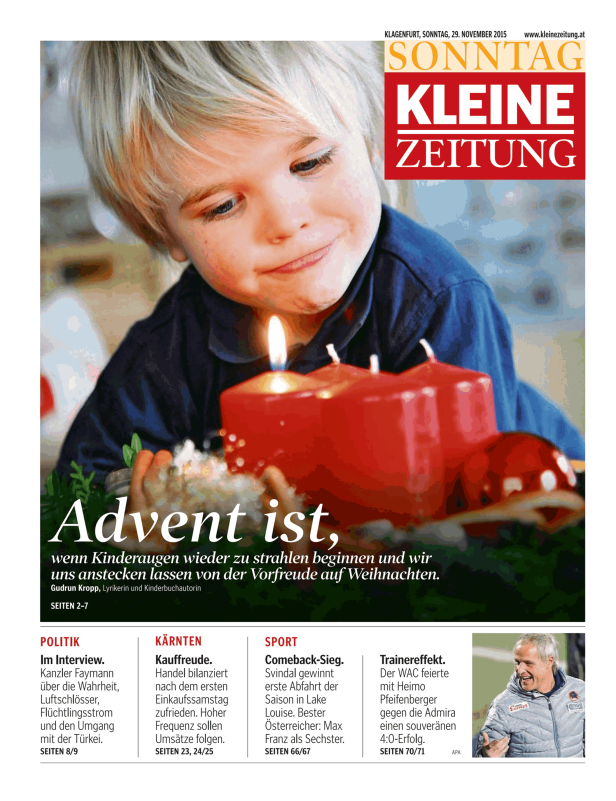 Ein Kind betrachtet lächelnd die Kerzen eines Adventskranzes.