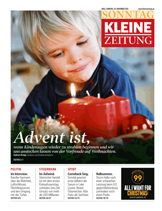 Ein Kind blickt auf die brennenden Kerzen eines Adventskranzes.