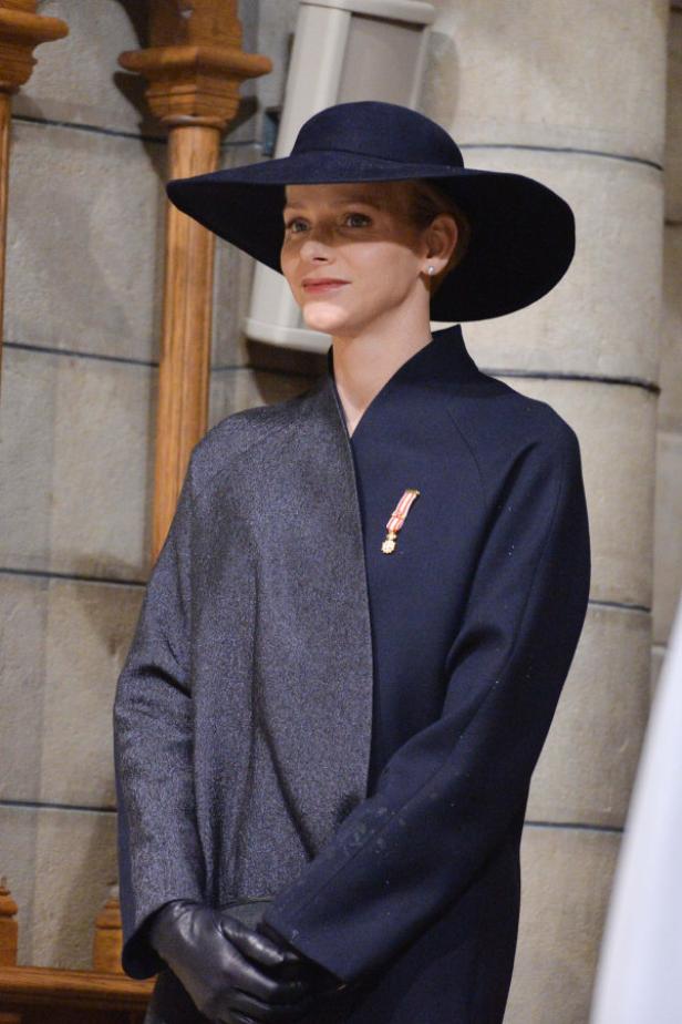 Fürstin Charlène von Monaco mit Hut und dunklem Mantel.