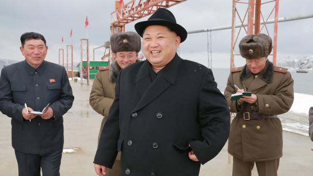 Kim Jong-un lächelt mit drei Begleitern an einem Pier.