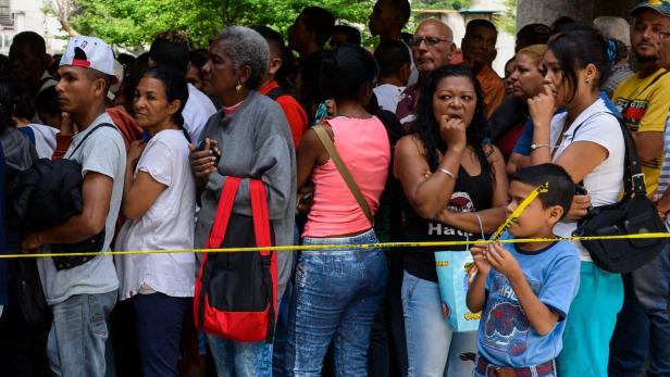 Eine Menschenmenge steht hinter einem gelben Absperrband.