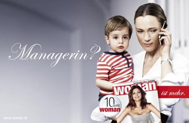 Eine Frau telefoniert, während sie ein Kind hält und eine „Woman“-Zeitschrift zeigt.