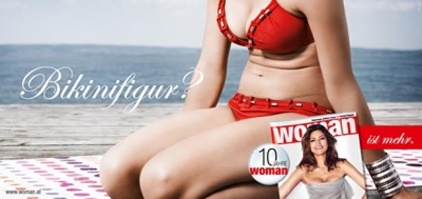 Eine Frau im roten Bikini sitzt am Strand, daneben eine Zeitschrift „Woman“.