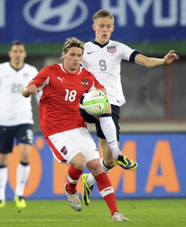 Zwei Fußballspieler kämpfen um den Ball während eines Spiels.