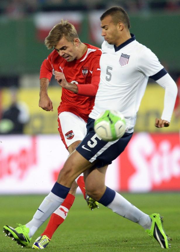 Zwei Fußballspieler kämpfen um den Ball während eines Spiels.