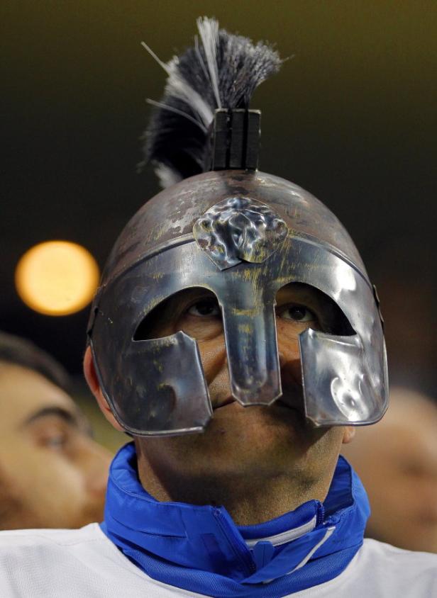Ein Mann trägt einen römischen Helm mit Federbusch.