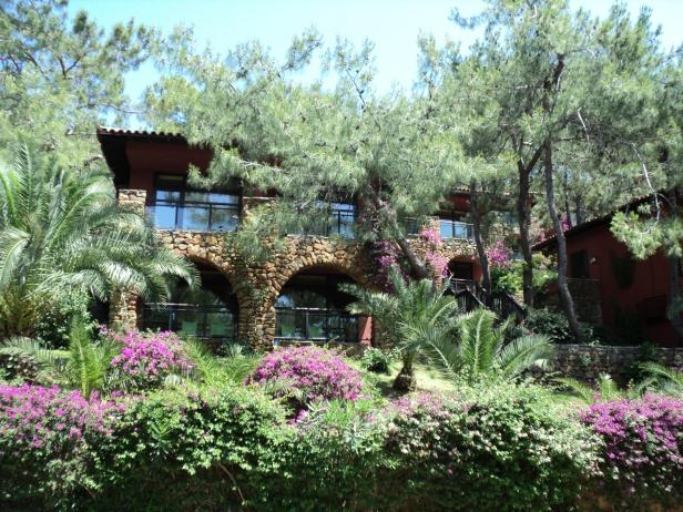 Ein zweistöckiges Gebäude mit Steinbögen, umgeben von üppiger Vegetation.