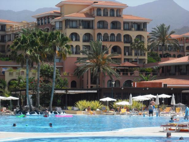 Ein großes Hotel mit Pool und vielen Menschen im Wasser.