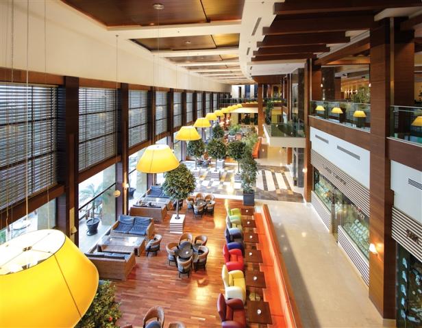 Die Lobby eines Hotels mit Sitzbereichen und großen Fenstern.