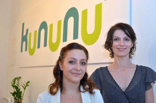Zwei Frauen posieren vor einem „kununu“-Logo.