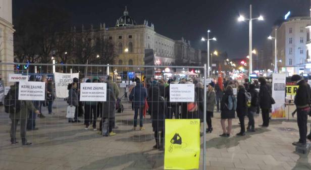 Eine abendliche Demonstration mit Schildern zum Thema Menschenrechte in Wien.