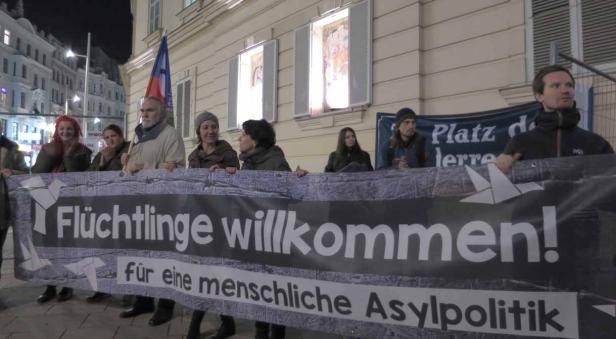 Eine Gruppe von Menschen hält ein Transparent mit der Aufschrift „Flüchtlinge willkommen! für eine menschliche Asylpolitik“.