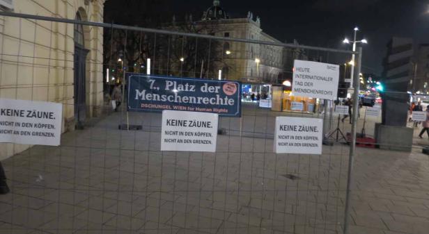 Auf dem „7. Platz der Menschenrechte“ in Wien demonstrieren Menschen gegen Zäune.