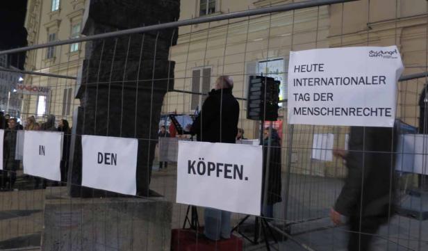 Eine Kundgebung zum Internationalen Tag der Menschenrechte mit Schildern „In den Köpfen“.
