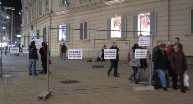 Eine Menschenmenge steht vor einem Gebäude mit Schildern, die „Keine Zäune. Nicht in den Köpfen. Nicht an den Grenzen“ zeigen.