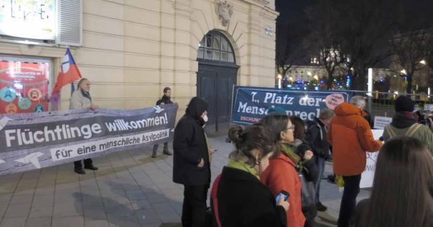Menschen demonstrieren mit einem Banner „Flüchtlinge willkommen!“ für eine menschliche Asylpolitik.