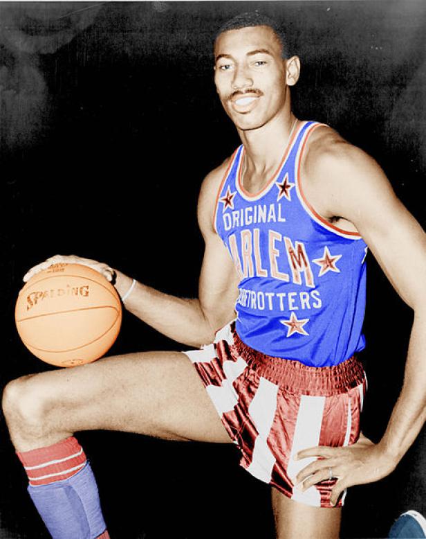 Ein Mitglied der Harlem Globetrotters posiert mit einem Basketball.