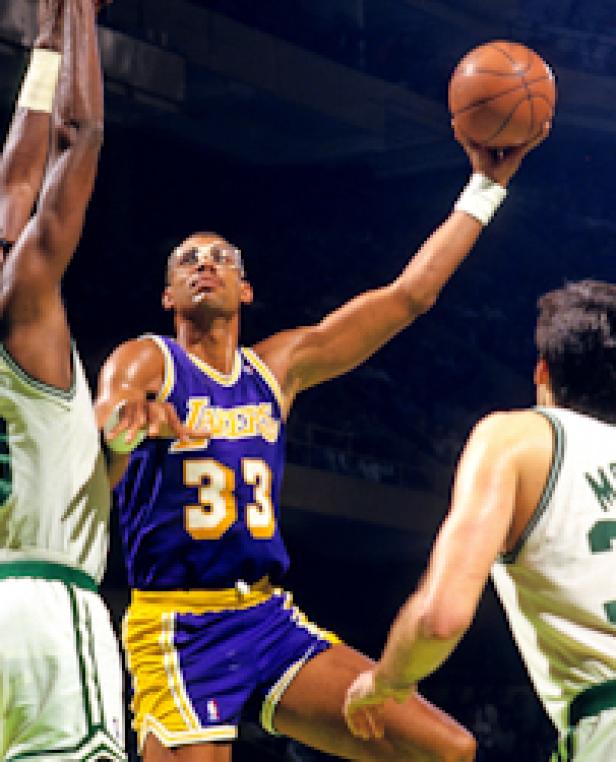 Kareem Abdul-Jabbar (Nr. 33) beim Basketballspiel, mit Schutzbrille und Lakers-Trikot.
