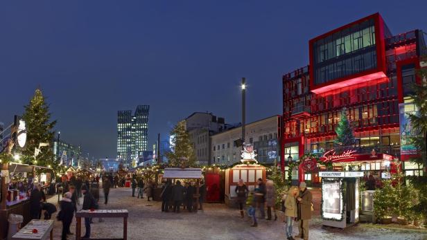 Ein belebter Weihnachtsmarkt vor dem rot beleuchteten Schmidt Tivoli in Hamburg.