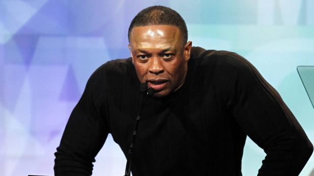 Dr. Dre spricht bei einer Veranstaltung in ein Mikrofon.