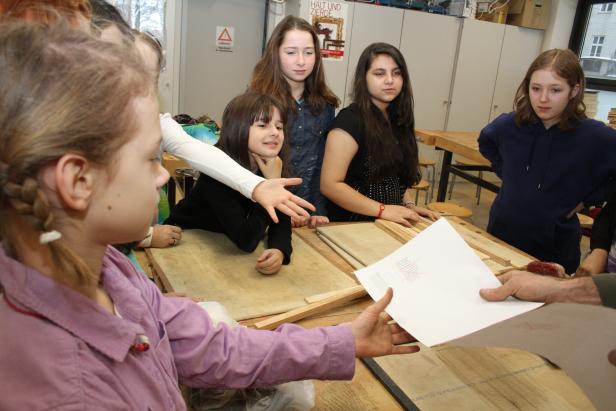 Eine Gruppe von Schülerinnen arbeitet an einem Projekt im Werkraum.