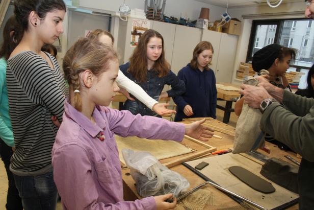 Eine Gruppe von Schülerinnen arbeitet mit Ton in einem Werkraum.