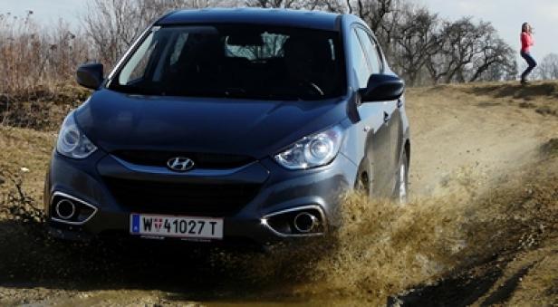 Ein grauer Hyundai ix35 fährt durch eine schlammige Wasserstelle.