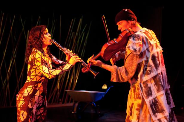 Eine Frau spielt Klarinette, ein Mann Geige auf einer Bühne.