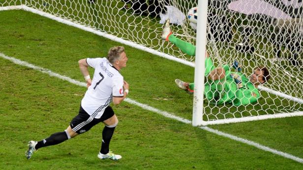 Bastian Schweinsteiger jubelt, während der Ball im Tor landet und der Torwart liegt am Boden.