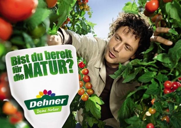 Ein Mann steht inmitten von Tomatenpflanzen mit einem Dehner-Schild, das fragt: „Bist du bereit für die Natur?“.