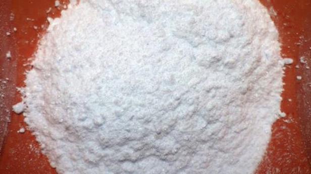 Ein Haufen feines, weißes Pulver auf einer roten Oberfläche.