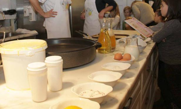 Auf einem Küchentisch stehen Zutaten für die Zubereitung von Crêpes bereit.