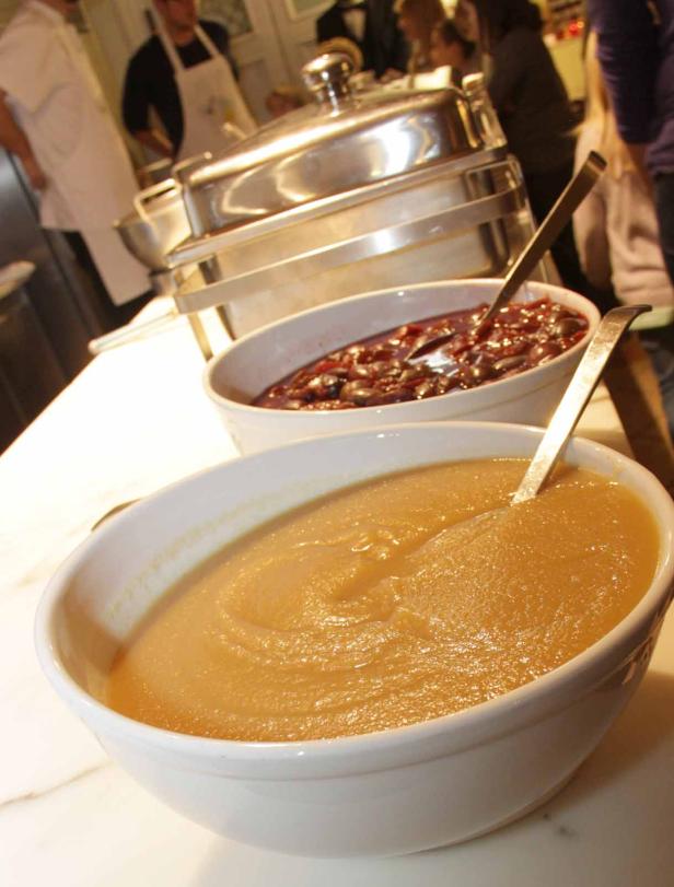 Ein Buffet mit Apfelmus und Kirschkompott in weißen Schüsseln.