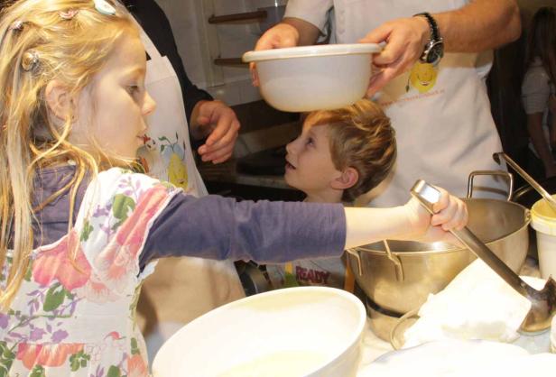 Zwei Kinder helfen beim Kochen in der Küche.