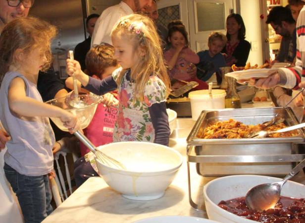 Kinder helfen beim Zubereiten von Speisen in einer Küche.