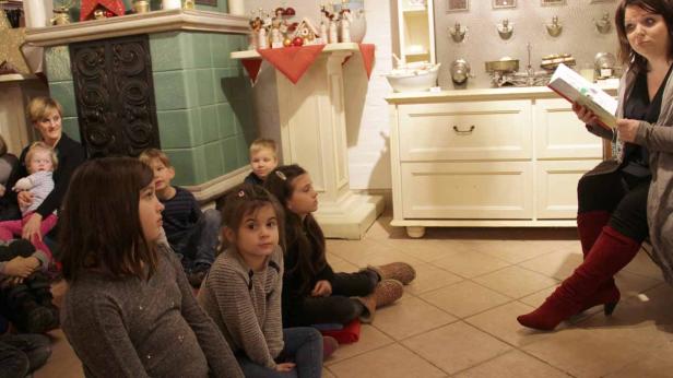 Eine Frau liest einer Gruppe von Kindern eine Geschichte vor.