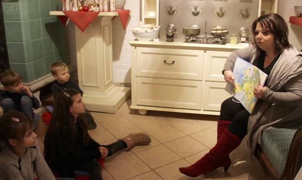 Eine Frau zeigt einer Gruppe von Kindern eine Karte von Europa.