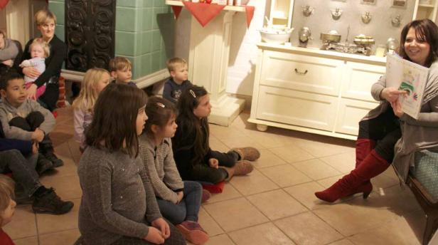 Eine Frau liest einer Gruppe von Kindern eine Geschichte vor.