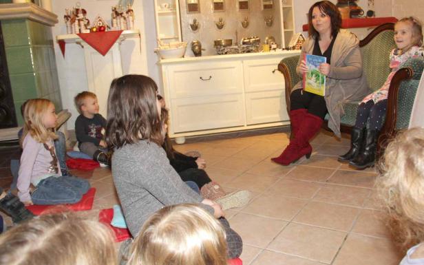 Eine Frau liest einer Gruppe von Kindern eine Geschichte vor.