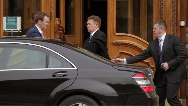 Mehrere Männer in Anzügen steigen aus einer schwarzen Limousine.