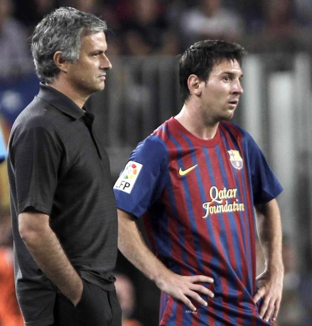 José Mourinho und Lionel Messi stehen nebeneinander auf dem Fußballplatz.